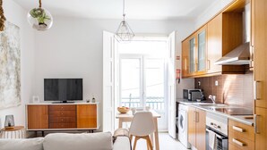 A modern kitchen with wooden cabinets, a built-in microwave, and a stainless steel sink. - Setubal Downtown - By Y Concept (Setúbal)