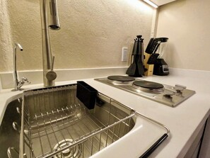 A kitchen with a stainless steel sink, a kettle, and a knife block. - Chic pied-à-terre in Coyoacán | Private Patio (Ciudad de México)