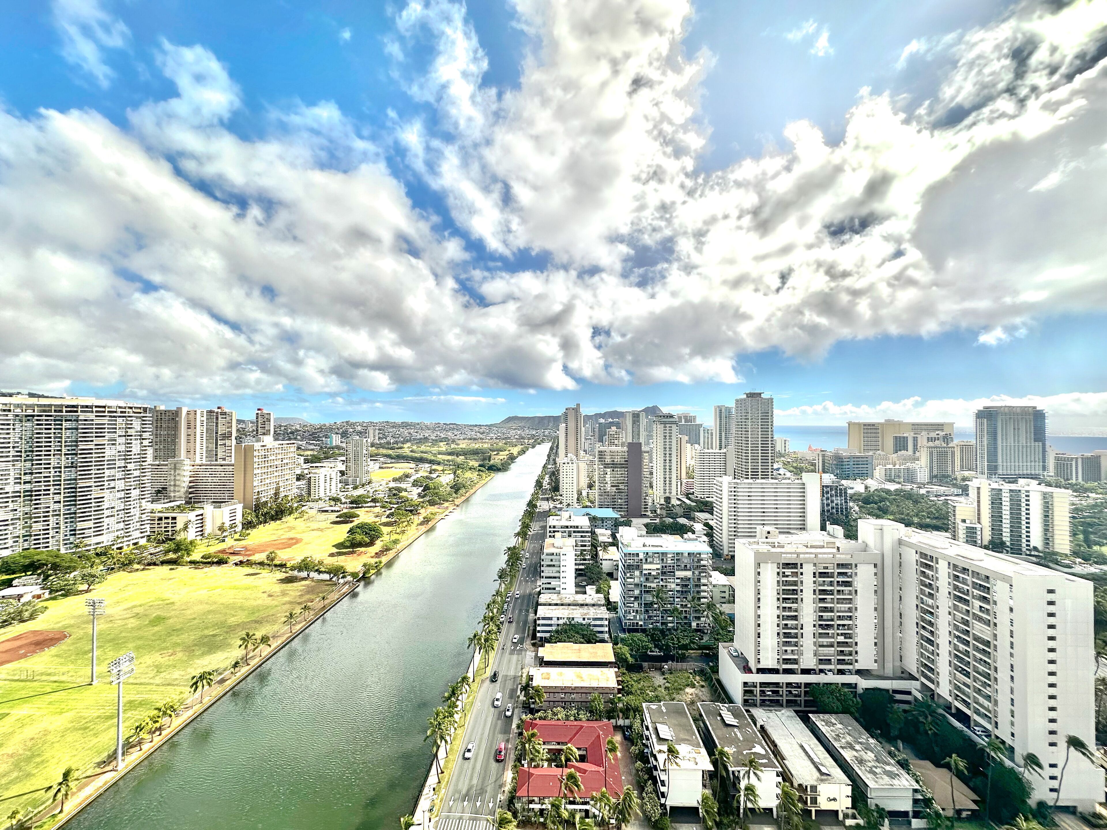 Paisagem urbana com um rio serpenteando, cercada por edifícios altos e um céu limpo.