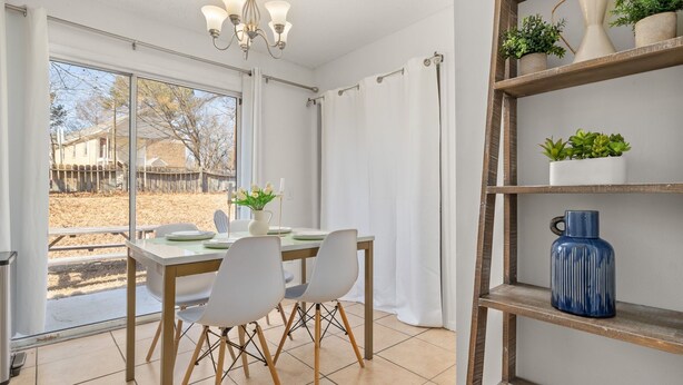 A dining area with a table and chairs, a chandelier, and a shelf with plants. - City-Close Durham Stay Near Downtown~Self Check-In~King Suite~Free Parking (Durham)