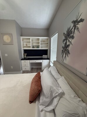 Ein Schlafzimmer mit einem Bett, einem Schreibtisch und einem Regal.