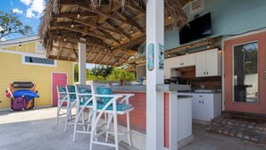 A covered outdoor seating area with white chairs and a bar. - Suite "Flamingo Pointe" with Shared POOL! (Bay St. Louis)