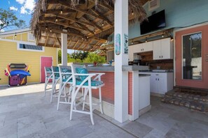 A covered outdoor seating area with white chairs and a bar. - Suite "Flamingo Pointe" with Shared POOL! (Bay St. Louis)