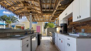 A kitchen with white cabinets, a coffee maker, and a thatched roof overhead. - Honeymoon Suite with Shared POOL! (Bay St. Louis)