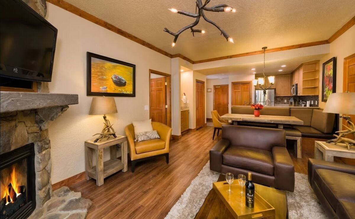 A cozy living room with a fireplace, leather sofas, and a dining area.