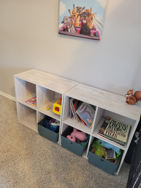 Une bibliothèque pour enfants, avec divers jouets et livres.