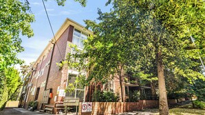 A multi-story brick building with a covered porch and a brick wall with a no parking sign. - South Yarra Apt | A/C, Parking & Easy Transport (South Yarra)