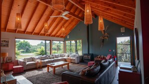Ein geräumiges Wohnzimmer mit hoher Decke, großen Fenstern und einem gemütlichen Kamin.