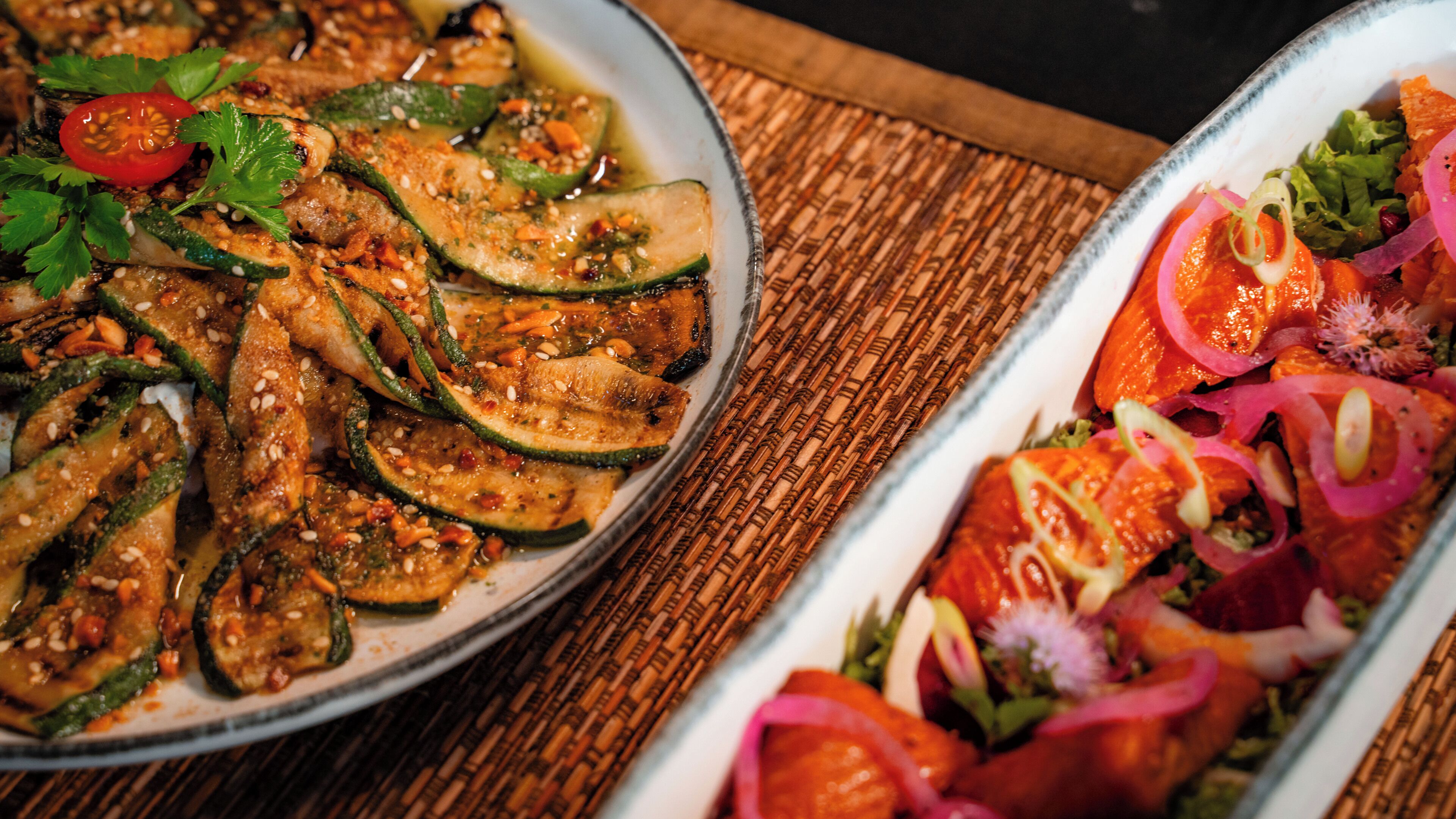 A wooden table with two dishes of food.