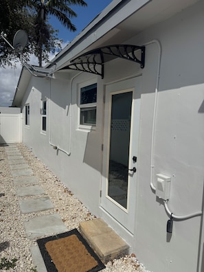 A white building with a door, windows, and a satellite dish. - Tropical Haven Dania (Dania Beach)
