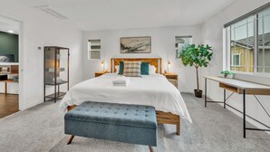 A modern bedroom with a large bed, bedside tables, a desk, and a potted plant. - Enjoyable 3-bedroom house with Firepit + Safe in charming Roseville (Roseville)