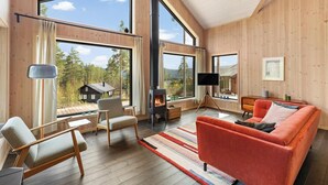 Un salon spacieux doté de grandes fenêtres, d’une cheminée et de meubles modernes.