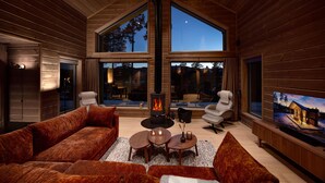 A cozy living room with a fireplace, large windows, and comfortable seating. - Lothlórien Lodge 8p - Four Bedroom Chalet, Sleeps 8 (Vrådal)