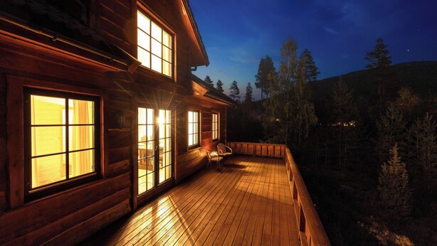 Een houten chalet met grote ramen en een terras.