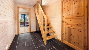 Een houten interieur met een trap, een deur en een raam.