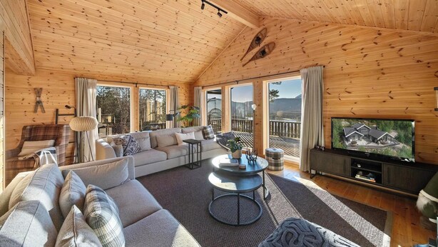 A cozy wooden cabin interior with a sofa, coffee table, and TV. - Verhøf Hytte 9p - Four Bedroom Chalet, Sleeps 9 (Vrådal)