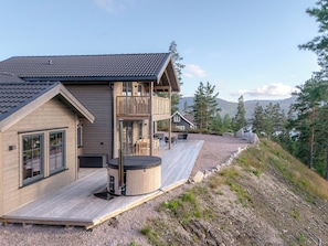 A wooden cabin with a deck, a hot tub, and a view of mountains and trees. - Gandalv Hytte 8p - Four Bedroom Chalet, Sleeps 8 (Vrådal)