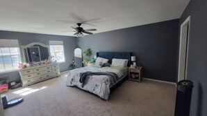 A bedroom with a bed, dresser, nightstands, and a ceiling fan. - Charming 3-bedroom house ready for the Masters (Martinez)
