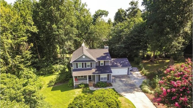 A two-story house with a front porch, surrounded by lush greenery and a well-maintained lawn. - Charming 3-bedroom house ready for the Masters (Martinez)