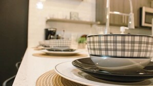 A kitchen with a white countertop, a black and white checkered bowl on a plate, and a woven placemat. - Downtown Retreat w/ Pool, Hot Tub & Fire Pit (Louisville)