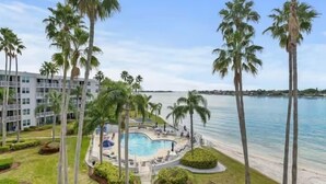 Ein Resort mit Swimmingpool, umgeben von Palmen und Blick auf den Ozean.