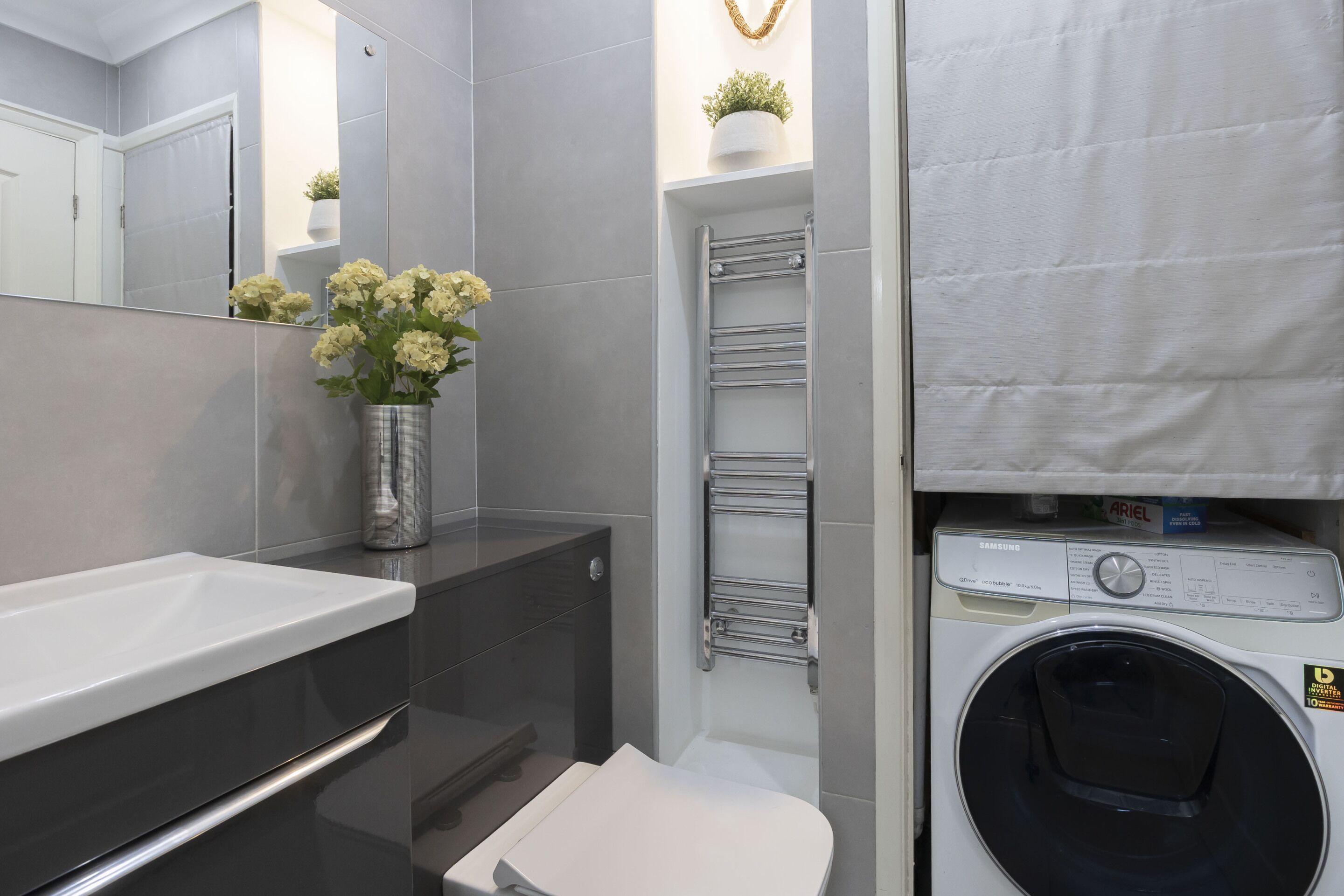 Ein modernes Badezimmer mit Waschbecken, Toilette und Waschmaschine.