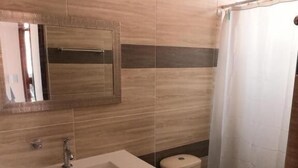 A bathroom with a sink, mirror, toilet, and shower curtain. - HOTEL COLONIAL A 100 MTS DE LA BASILICA (Guadalajara de Buga)