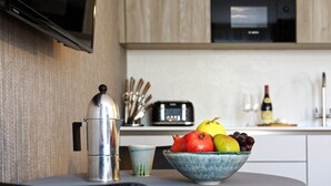 Una cocina con un cuenco de fruta, una cafetera y un tostador.