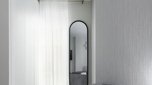A modern room with a grey sofa, a large mirror, and a wooden floor. - Studio near Oxford Street (London)