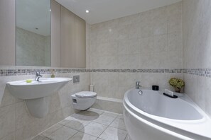 Une salle de bain moderne avec un lavabo, des toilettes et une baignoire.