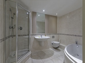 A modern bathroom with a glass-enclosed shower, a sink, a toilet, and a bathtub. - Studio near Oxford Street (London)