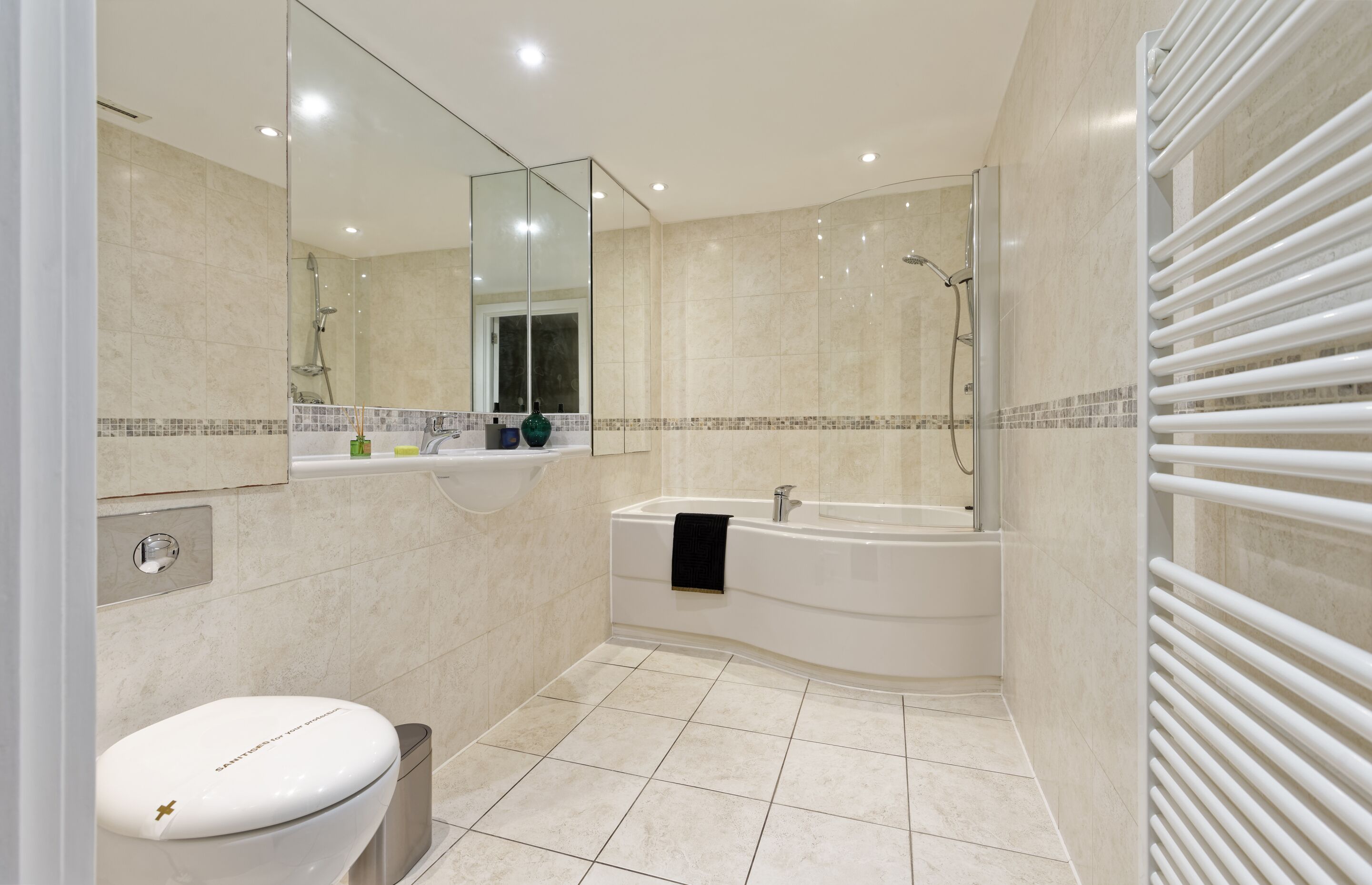 A modern bathroom with a toilet, sink, and bathtub.