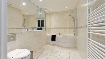 A modern bathroom with a toilet, sink, and bathtub.