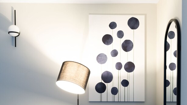Een moderne kamer met een donkerblauwe fauteuil, een vloerlamp, een wandspiegel en een abstract kunstwerk.