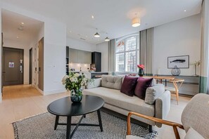 Ein modernes Wohnzimmer mit einer Couch, einem Couchtisch und einem Essbereich mit Tisch und Stühlen.