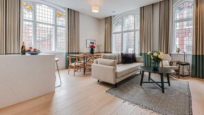 Un salon spacieux avec un canapé, une table basse et un coin repas.