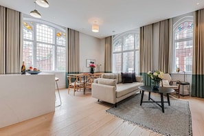Un salon spacieux avec un canapé, une table basse et un coin repas.