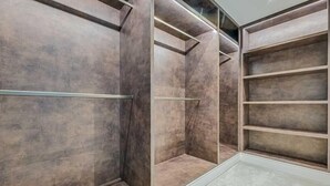 Een moderne kast met spiegeldeuren, ingebouwde planken en een metalen kledingroede.
