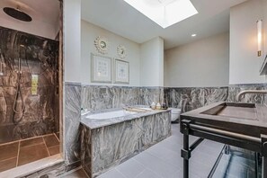 A modern bathroom with a marble vanity, a separate sink, and a shower area. - Three-Bedroom Duplex Penthouse (London)
