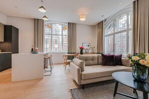 Una sala de estar moderna con un sofá, una mesa de comedor y una zona de cocina.