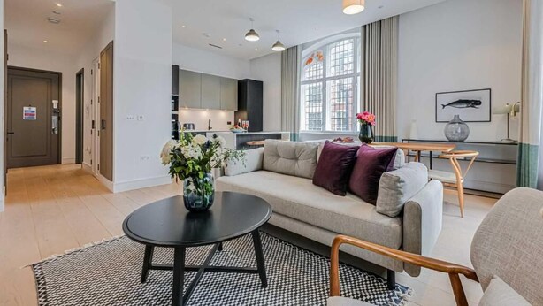 Un salon moderne comprenant un canapé, une table basse et un coin repas avec une table et des chaises.