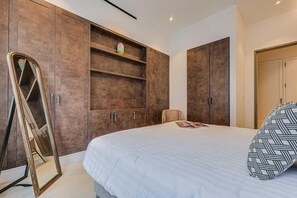 Une chambre à coucher avec un lit, un miroir, une armoire et une chaise.