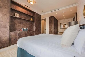 Une chambre avec un grand lit, une armoire intégrée et un miroir.