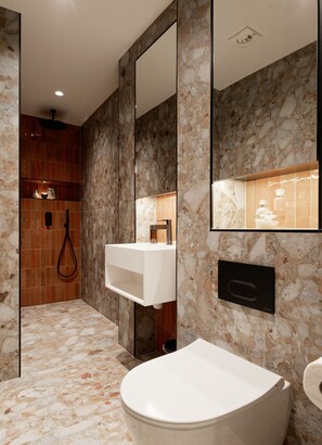 Un baño moderno con una bañera independiente, un lavamanos empotrado y una zona de ducha.