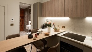 Una cuina moderna amb armaris de fusta, una illa central amb seients, un forn integrat i un petita rentatres.