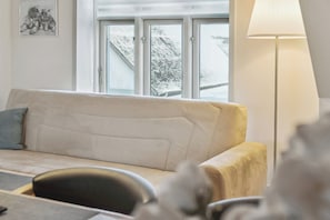 Ett vardagsrum med en soffa, ett bord och en lampa.