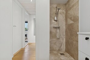 A modern bathroom with a shower, a toilet, and a sink. - New holiday home close to the beach (Middelfart)