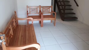 Ein Zimmer mit einer hölzernen Bank, einem Holzstuhl und einer Treppe.