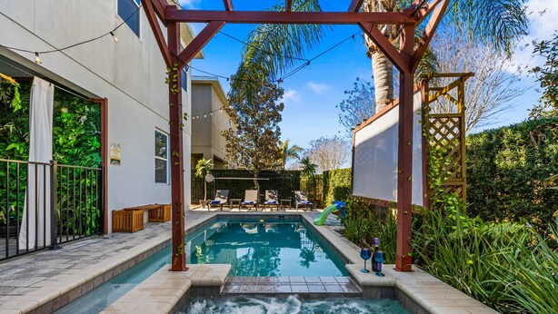 A swimming pool with a hot tub, surrounded by a pergola and lounge chairs. - 8 Br Magical Themed Villa Close To Disney (Kissimmee)