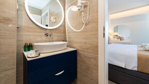 A bathroom with a large round mirror, a sink, and a handheld showerhead. - Zaratino Room 4 in Zadar (Zadar)